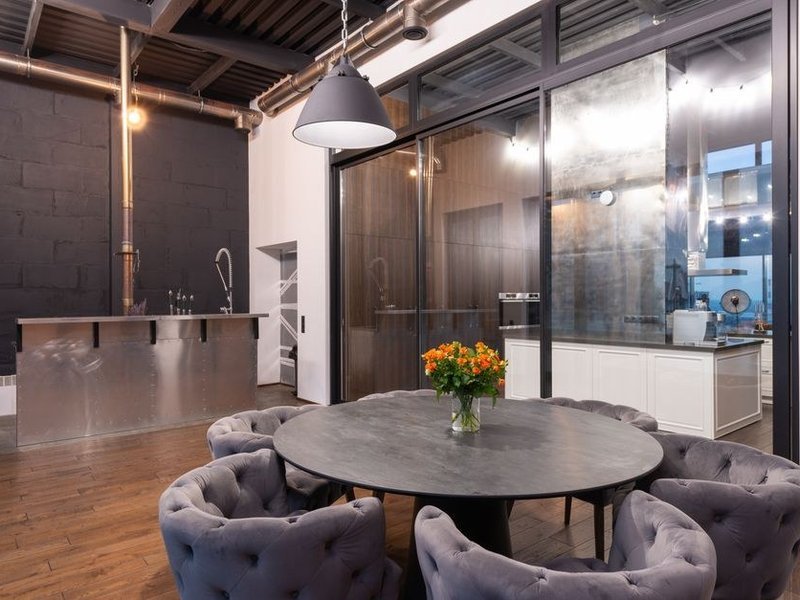 Îlot central et verrière d'atelier séparant la cuisine ouverte du séjour dans un loft industriel de Vaise, Lyon 9, grand plan de travail et hauteur d'atelier