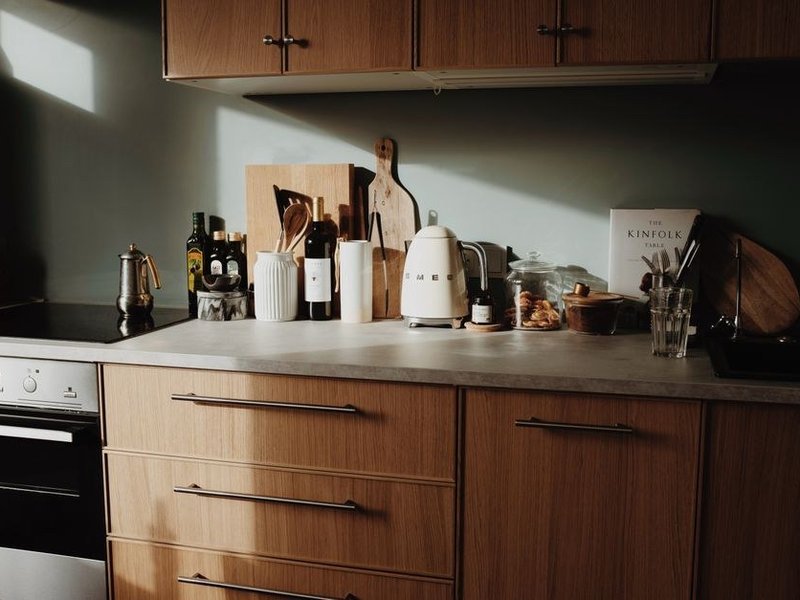 Petite cuisine d'une maison du cœur ancien de Marennes repensée au centimètre, plan filant et colonnes de rangement, ouverte sur une cour à l'arrière