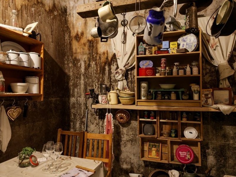 Cuisine d'une maison ancienne de Mornant rénovée, murs de pierre conservés, plomberie et électricité anciennes reprises et meubles neufs posés près de la collégiale