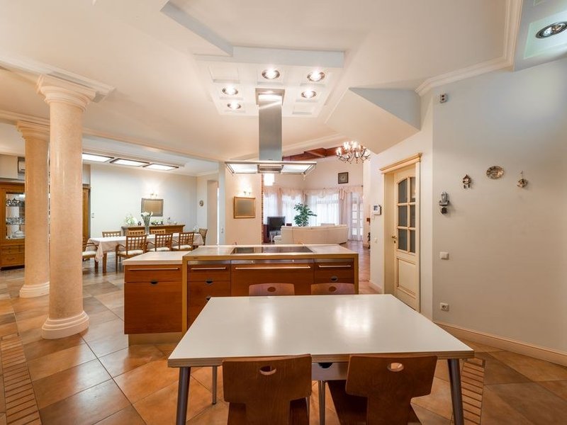 Cuisine d'appartement en copropriété à Pierre-Bénite posée autour d'une colonne technique gardée en place, plan de travail continu et rangements montés en hauteur
