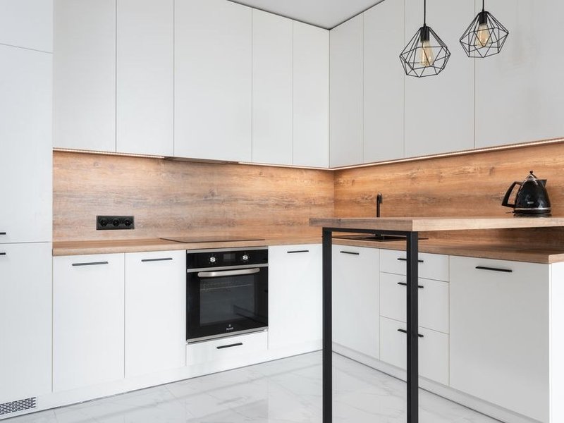 Cuisine fermée d'appartement de grand ensemble à Rillieux-la-Pape réagencée en L, colonnes toute hauteur et plan de travail continu pour exploiter chaque recoin