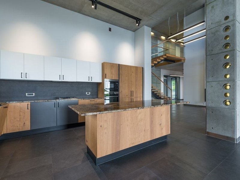 Îlot central pratique posé dans un pavillon récent de Saint-Genis-les-Ollières, cuisine ouverte sur le salon, réseaux amenés au centre, tour de l'îlot dégagé