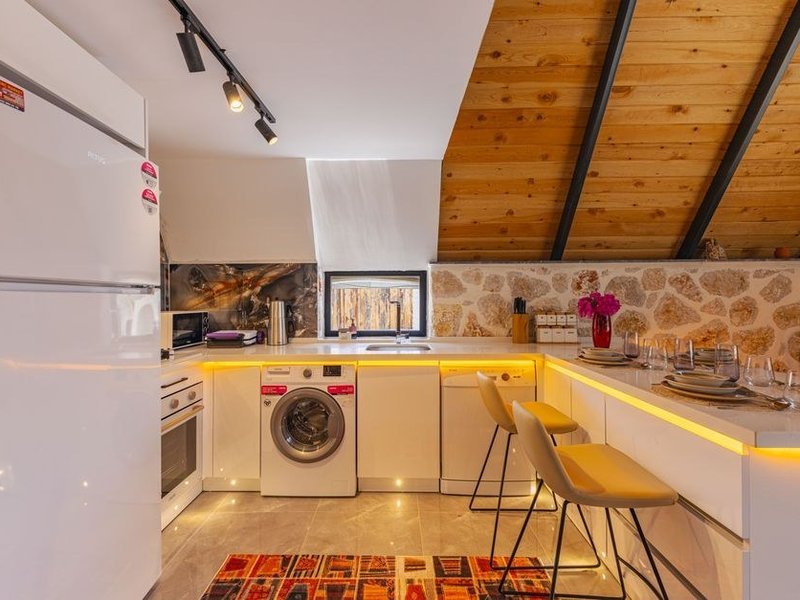 Meubles de cuisine ajustés au fileur contre un mur de pierre irrégulier dans une maison ancienne de Saint-Symphorien-d'Ozon