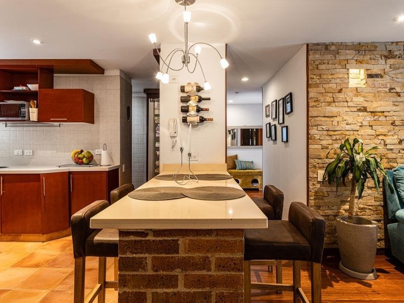 Cuisine sur mesure ajustée aux murs de pierre irréguliers d'une maison ancienne du bourg de Saint-Symphorien-d'Ozon