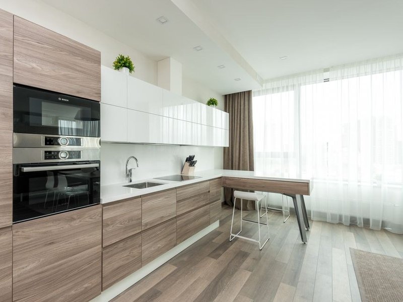 Cuisine sur mesure posée dans un appartement de copropriété du plateau de Sainte-Foy-lès-Lyon, meubles ajustés autour de la colonne technique commune et des gaines de VMC