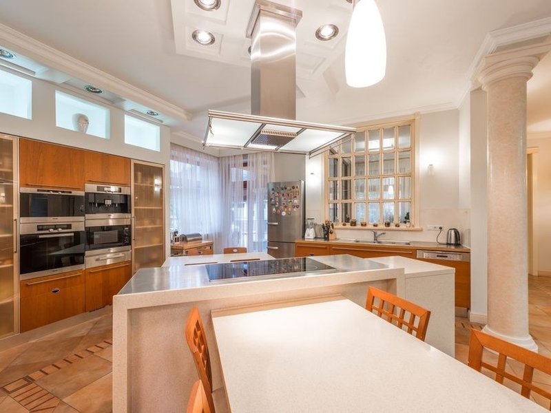 Cuisine composée dans un logement d'ancienne caserne reconvertie de Castellane à Sathonay-Camp, colonnes toute hauteur profitant du plafond haut et linéaire calé sur la trame des fenêtres