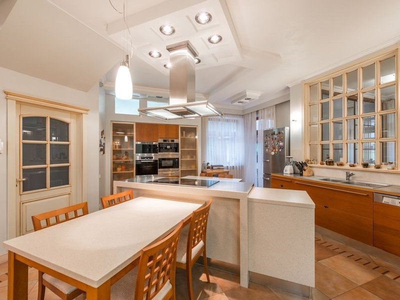 Cuisine ouverte avec îlot central dans un pavillon du plateau de Sathonay-Camp, ouverte sur le séjour, coin repas et rangements intégrés à l'îlot
