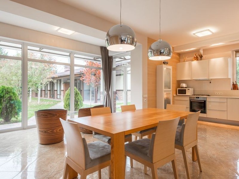 Cuisine d'un pavillon de Souzy orientée vers une grande baie ouverte sur le jardin