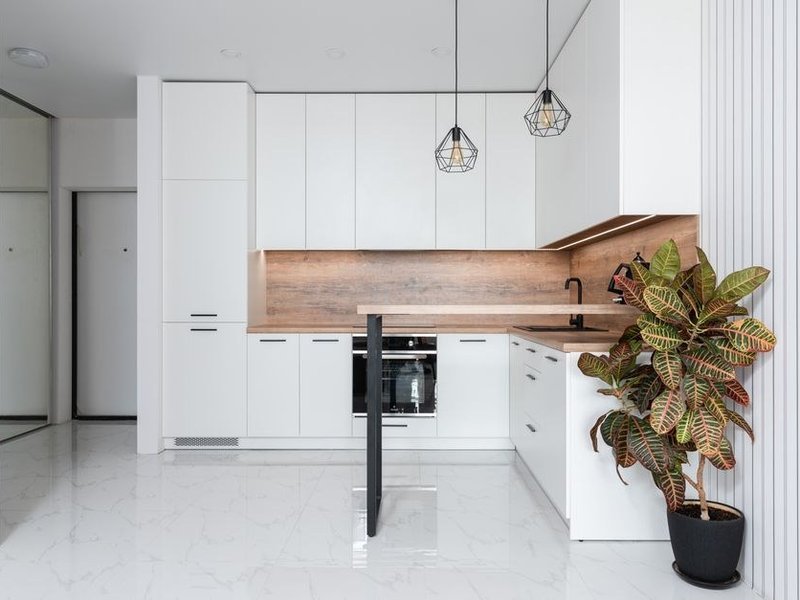 Cuisine équipée fonctionnelle posée dans un logement rénové d'un grand ensemble à Vaulx-en-Velin, colonnes toute hauteur et rangements optimisés pour une famille