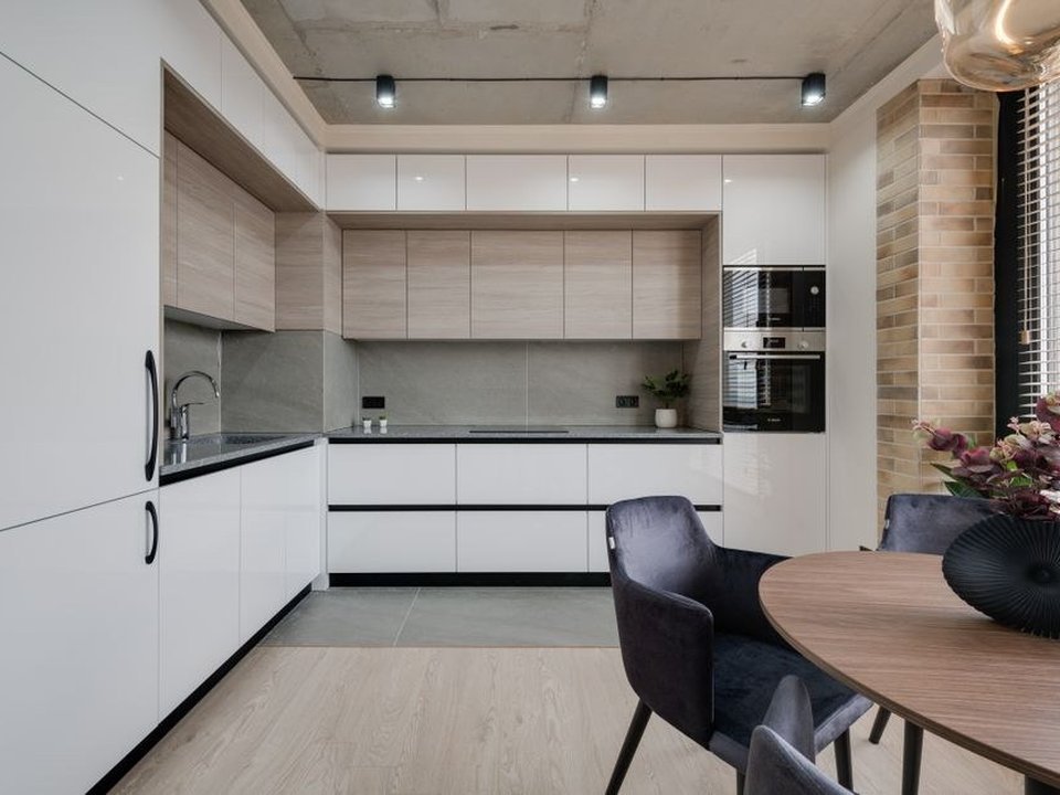 Cuisine fermée et étroite d'un appartement de copropriété des années 60-70 à Vénissieux réagencée en cuisine équipée fonctionnelle, meubles posés le long de la colonne technique commune d'eau conservée