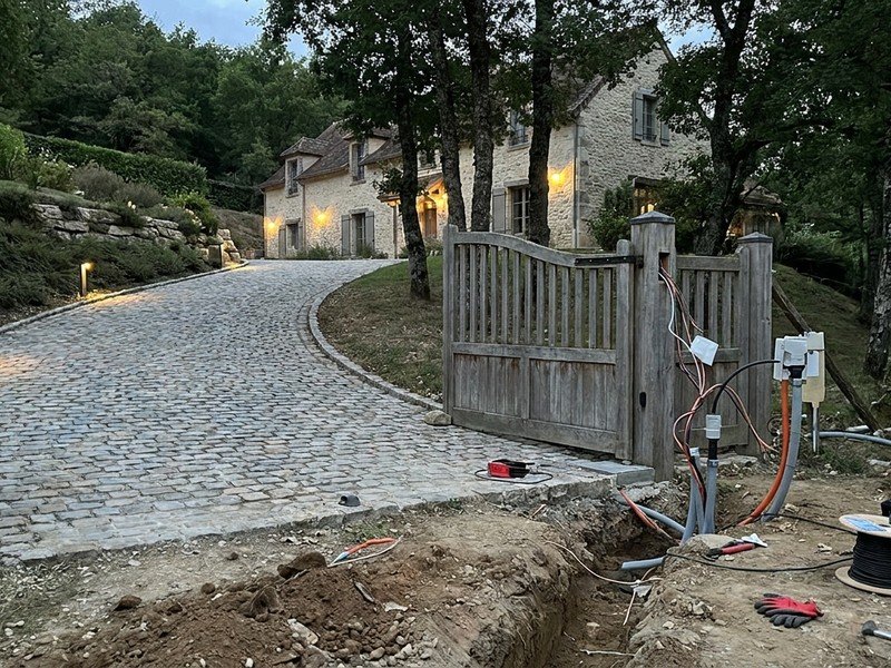 Éclairage extérieur des marches d'un terrain en pente et portail motorisé en bas de rampe dans une propriété des coteaux de Caluire