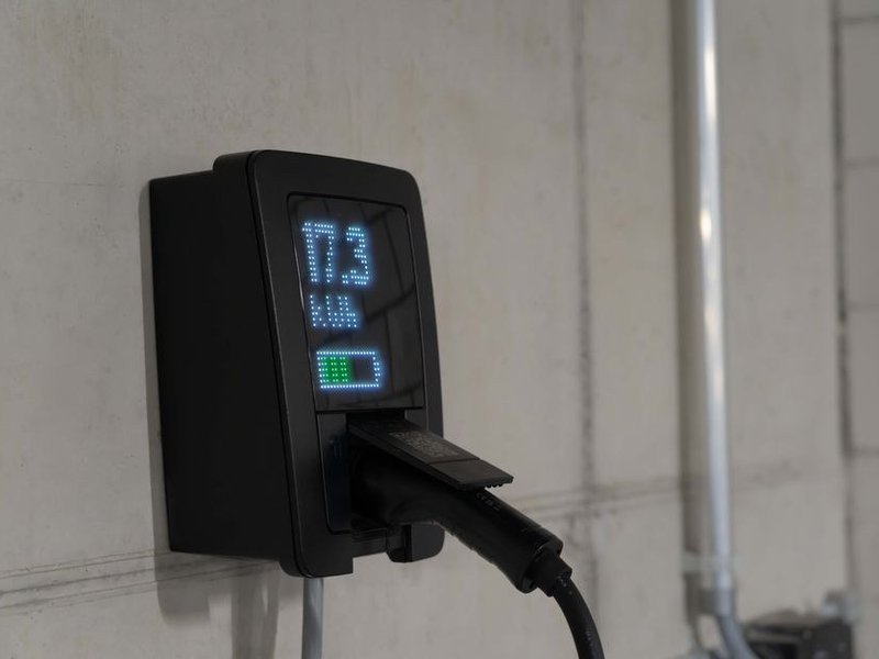 Borne de recharge de véhicule installée dans le garage d'un pavillon neuf de Décines, alimentée par un circuit dédié depuis le tableau à rail DIN