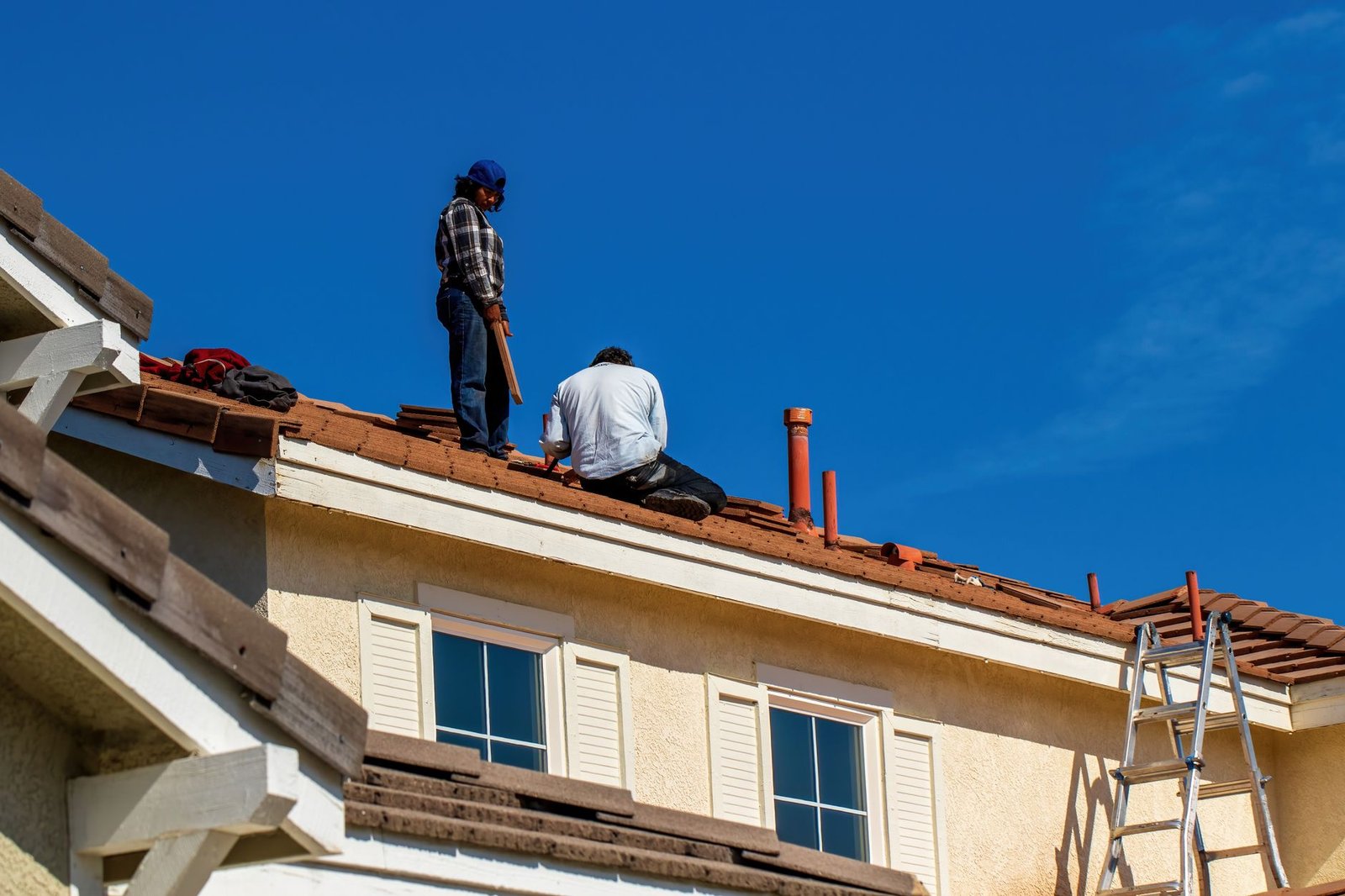 Couvreurs réparant une fuite sur une toiture en tuiles à Lyon