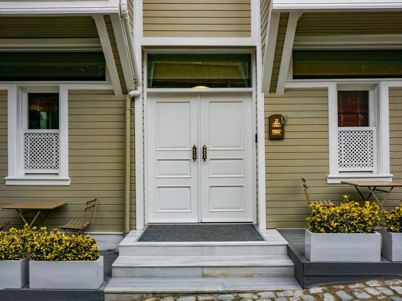 Porte d'entrée sobre et bien isolée d'une maison de Bessenay, donnant sur la rue exposée au soleil
