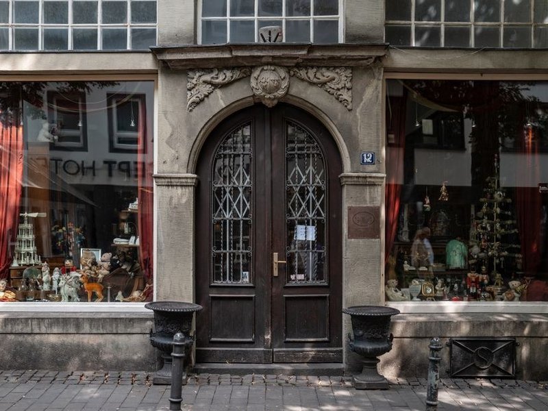Devanture et porte en bois d'un commerce en rez-de-chaussée dans la rue commerçante du centre de Brignais