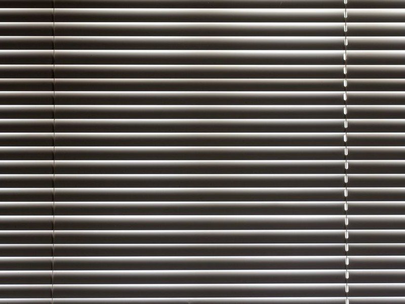 Brise-soleil orientable à lames installé au-dessus d'une grande baie vitrée exposée plein sud sur une maison de coteau à Caluire