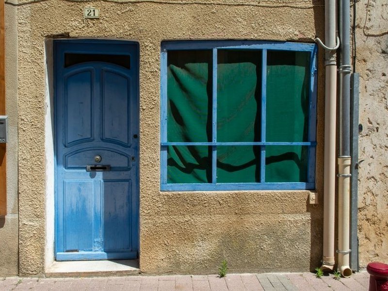 Fenêtre bois à petits carreaux et porte d'entrée ancienne d'une maison de bourg à rénover à Chaponnay