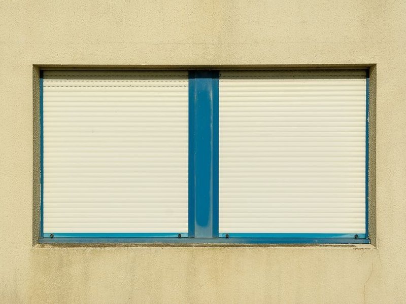 Volet roulant motorisé solaire posé sur une large façade de pavillon aéré à Chassieu, capteur solaire visible sur le coffre
