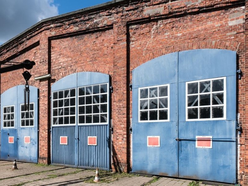Grandes portes d'un bâtiment de la zone du Grand Parilly à Corbas, menuiseries à remplacer