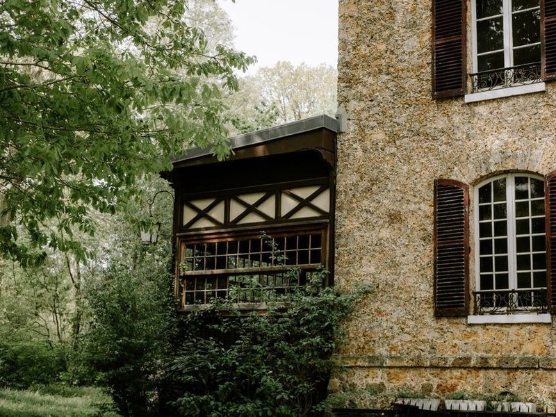 Fenêtres neuves à vitrage isolant posées sur une maison de pierre du fond de vallée de Courzieu, façade à l'ombre du versant boisé