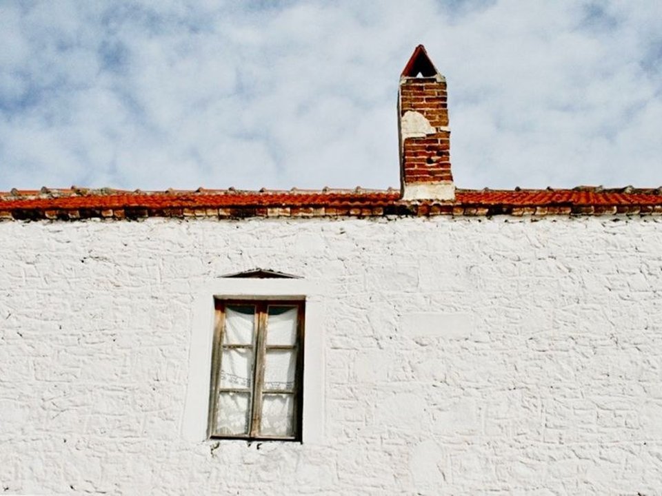 Façade d'une maison de village à Courzieu, fenêtres et volets à reprendre, au fond de la vallée boisée des Monts du Lyonnais