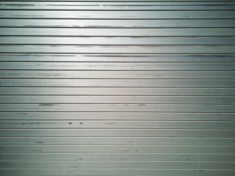 Portail coulissant motorisé en aluminium et porte d'entrée isolée fermant l'accès d'un pavillon à Craponne