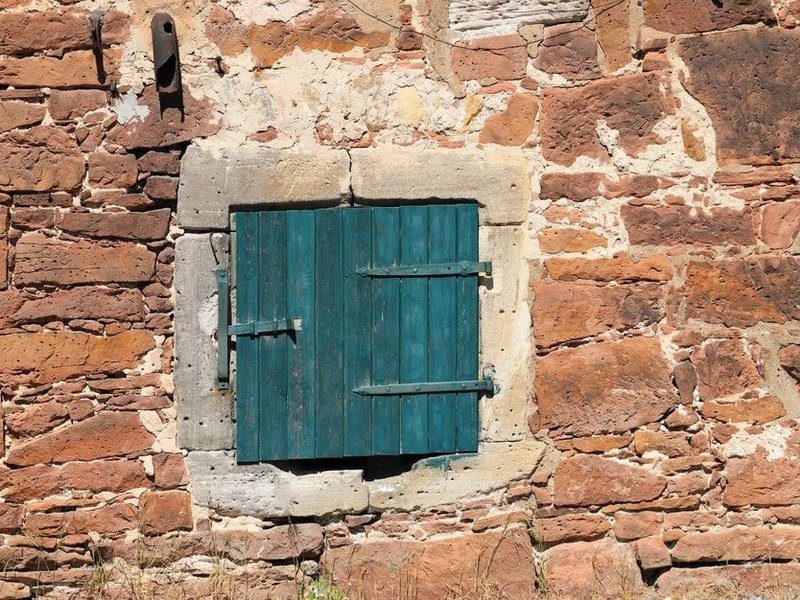 Volets battants en bois sur les fenêtres d'une maison en pierre dorée du coteau de Curis-au-Mont-d'Or