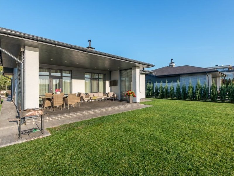 Large baie coulissante d'un pavillon de Dardilly ouverte sur la terrasse et le grand jardin, vitrage isolant à profilés fins