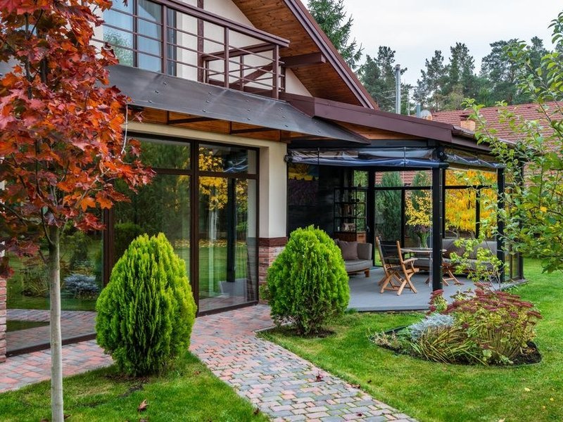 Grande baie coulissante en aluminium à profil fin posée dans une maison contemporaine de Francheville, ouverte sur une terrasse et un jardin arboré