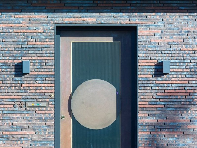 Porte d'entrée aluminium isolante à serrure multipoints posée sur un pavillon de Grézieu-la-Varenne, dans le style des fenêtres