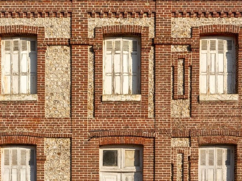 Volet roulant et persienne rénovés sur la façade d'un immeuble de coteau escarpé à La Mulatière