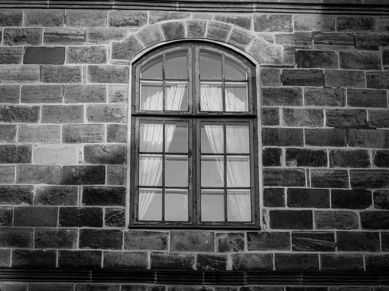 Fenêtre bois à petits bois restaurée sur la façade en pierre dorée d'une ancienne ferme du bourg de Limonest