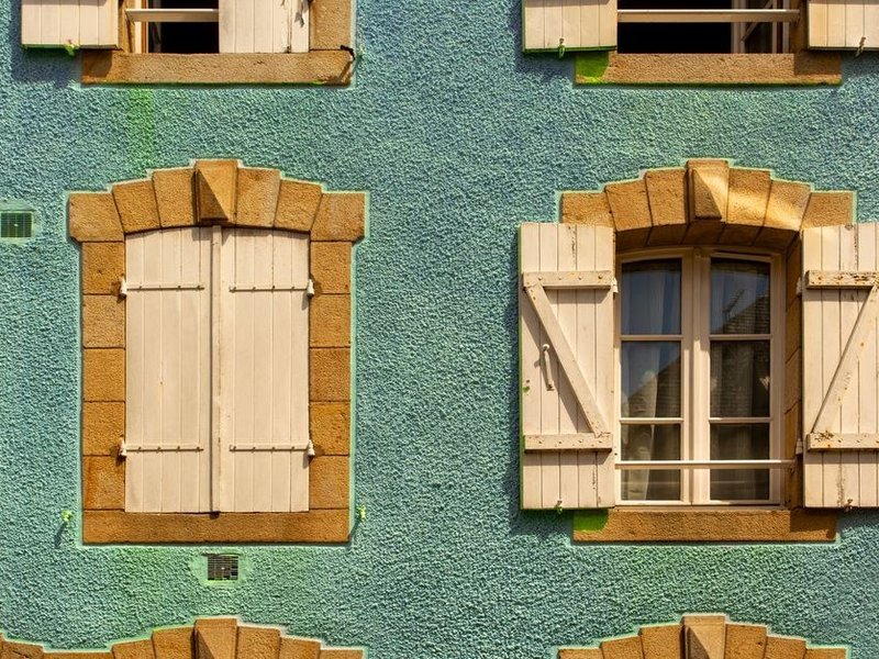 Volets battants en bois repeints sur la façade d'une maison ancienne des coteaux de Limonest