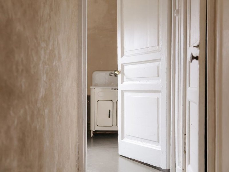 Porte palière en bois moulurée restaurée sur le palier d'un immeuble bourgeois de la Préfecture à Lyon 3