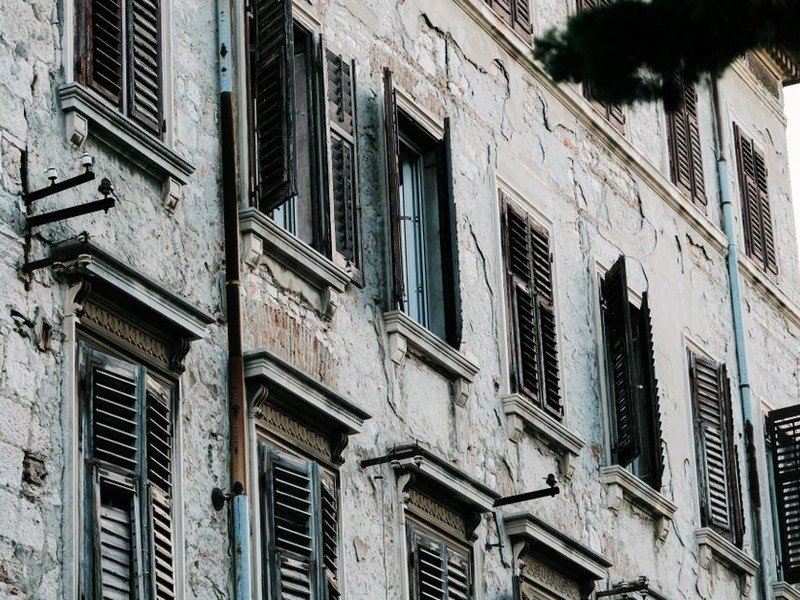 Persiennes bois repeintes sur la façade d'un immeuble haussmannien des Brotteaux à Lyon 6, aspect coordonné au ravalement