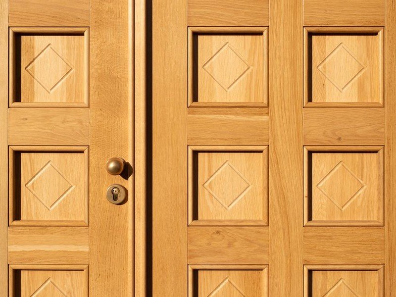 Porte palière de standing en bois moulurée restaurée sur le palier d'un immeuble bourgeois de Lyon 6