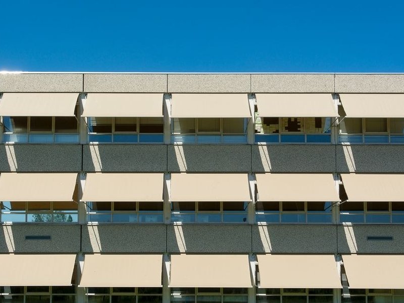 Volet roulant motorisé et store extérieur au-dessus d'une baie d'un pavillon de Marcy-l'Étoile pour gérer le soleil filtré par les arbres