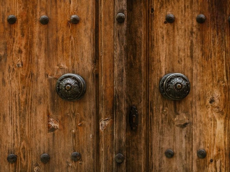 Porte ancienne en bois clouté d'une maison de pierre près de la tour de Montrottier