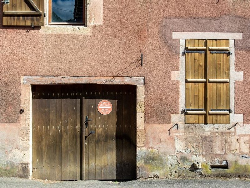 Volet battant bois d'une maison ancienne de Mornant restauré et remis en jeu sur ses gonds