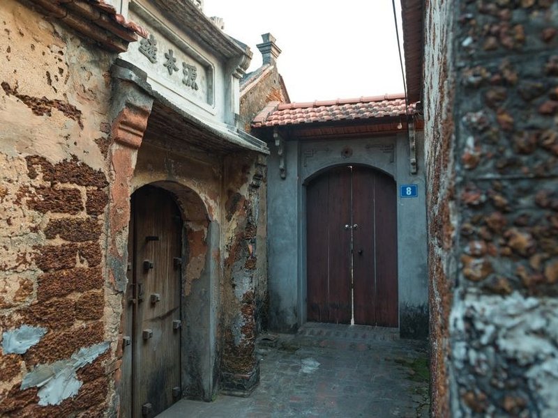Porte d'entrée ancienne en bois ouvrant sur une rue étroite du bord de Saône à Neuville-sur-Saône