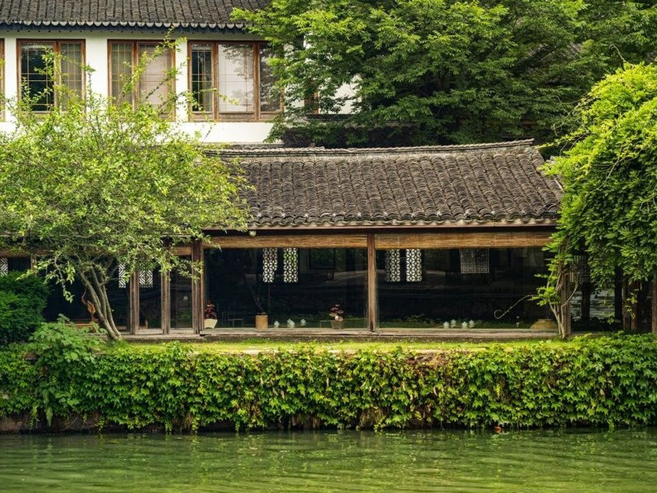 Menuisier restaurant une fenêtre bois d'une maison de mariniers donnant sur les quais de Saône à Neuville-sur-Saône