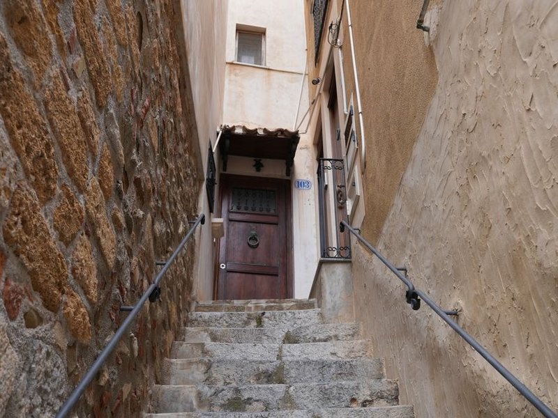 Porte d'entrée ancienne en bois donnant directement sur une rue étroite du centre-bourg d'Oullins