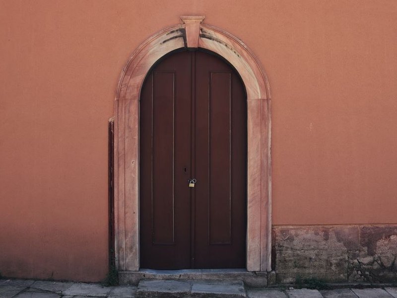 Porte d'entrée bois posée dans un encadrement en pierre, seuil étanché, sur une maison du village de Poleymieux-au-Mont-d'Or