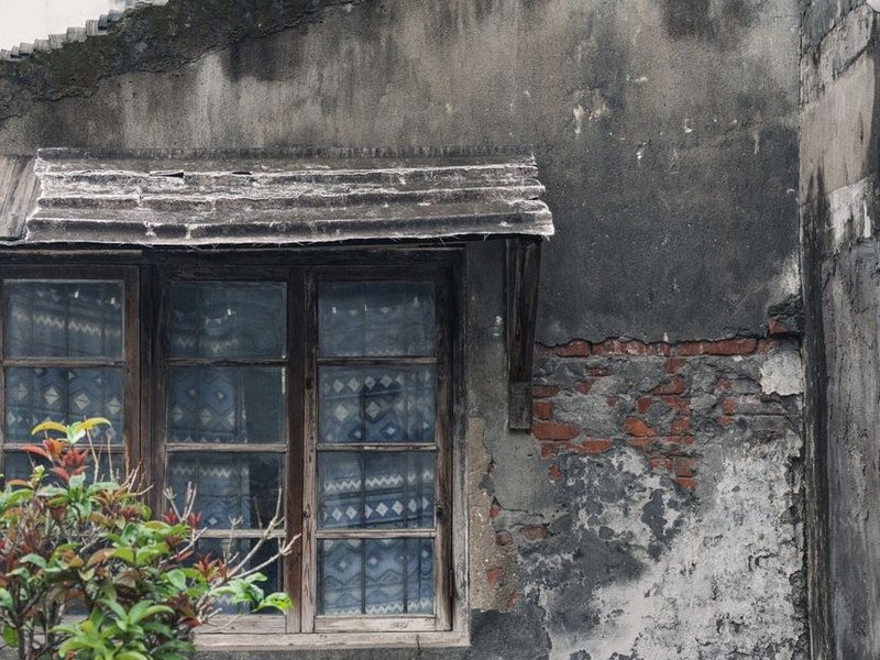 Ancienne fenêtre à simple vitrage et huisserie bois usée d'une maison de ville en brique à Saint-Fons avant remplacement