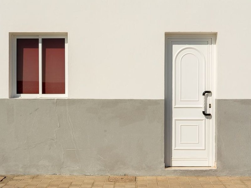 Porte d'entrée contemporaine en aluminium d'un pavillon de Saint-Genis-les-Ollières, sobre et bien isolée, accordée aux fenêtres reprises