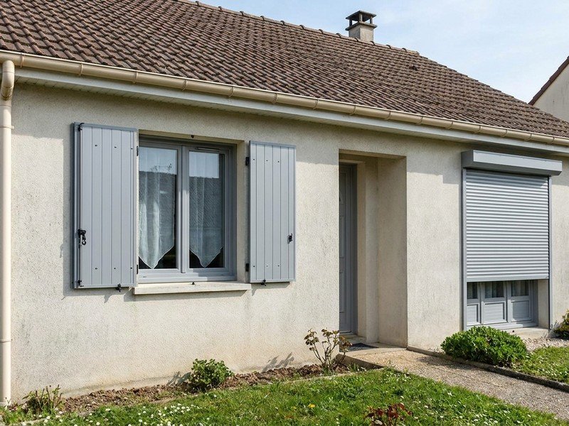 Volets battants aluminium et volet roulant motorisé posés sur les fenêtres d'un pavillon de Saint-Priest
