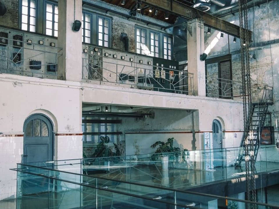 Loft aménagé dans une ancienne usine de soie TASE réhabilitée du Carré de Soie à Vaulx-en-Velin, avec une grande verrière métallique et de larges châssis vitrés