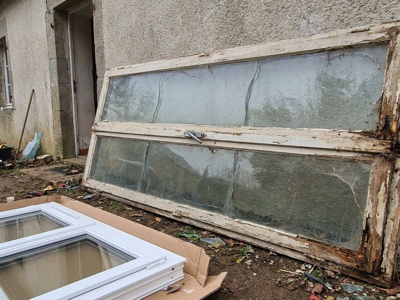 Ancienne fenêtre bois à simple vitrage d'un pavillon ouvrier de Vénissieux déposée pour être remplacée par une menuiserie isolante