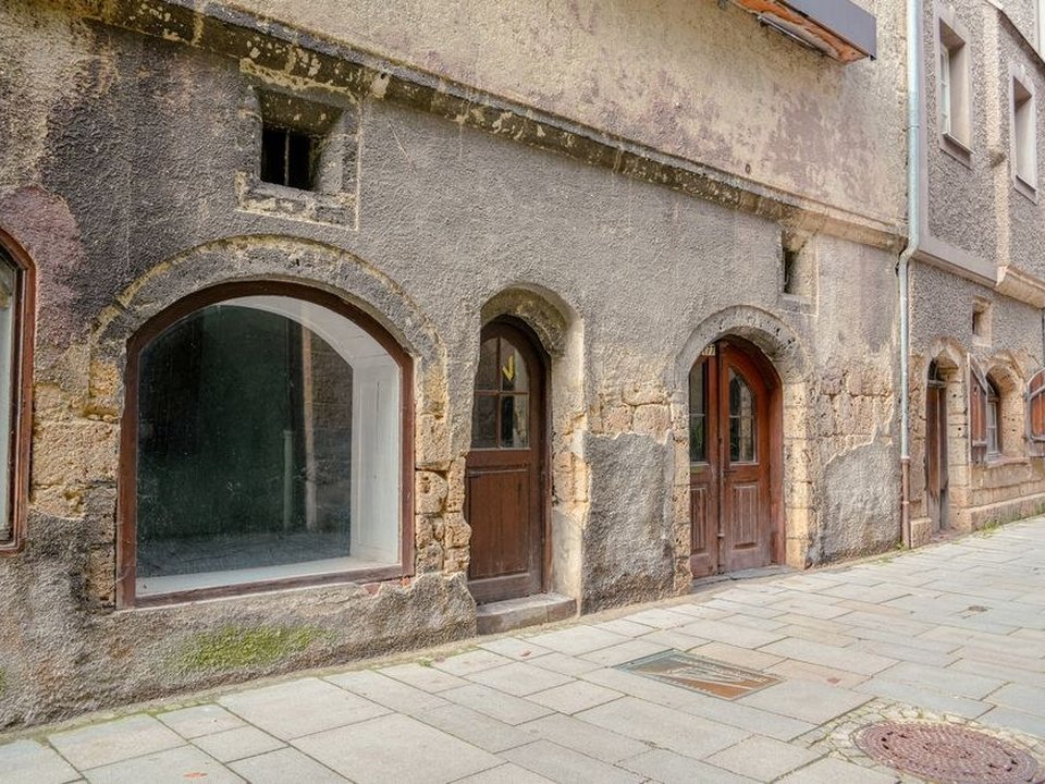 Menuisier remplaçant une fenêtre bois sur un immeuble ancien en pierres dorées du centre de Villefranche-sur-Saône, façade Renaissance et petits bois respectés