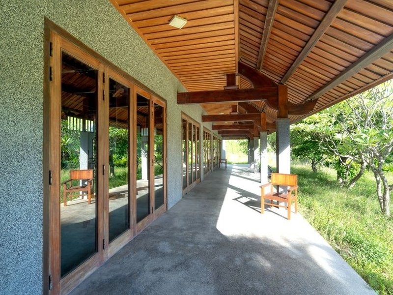Baie coulissante d'un pavillon de Vourles ouverte sur la terrasse et le jardin arboré du coteau